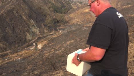 a man rolls block fo salt into a burned canyon to help feed wildlife displaced by the thomas wildfire in 2017