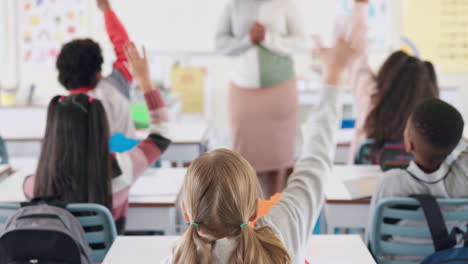 students raising hands in classroom