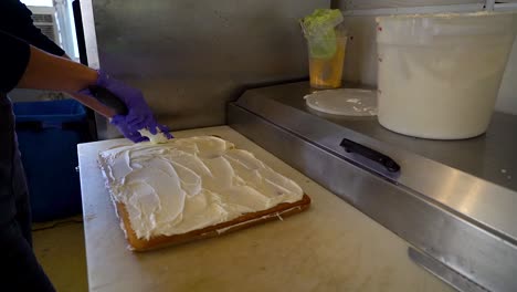 baker frosting a cake