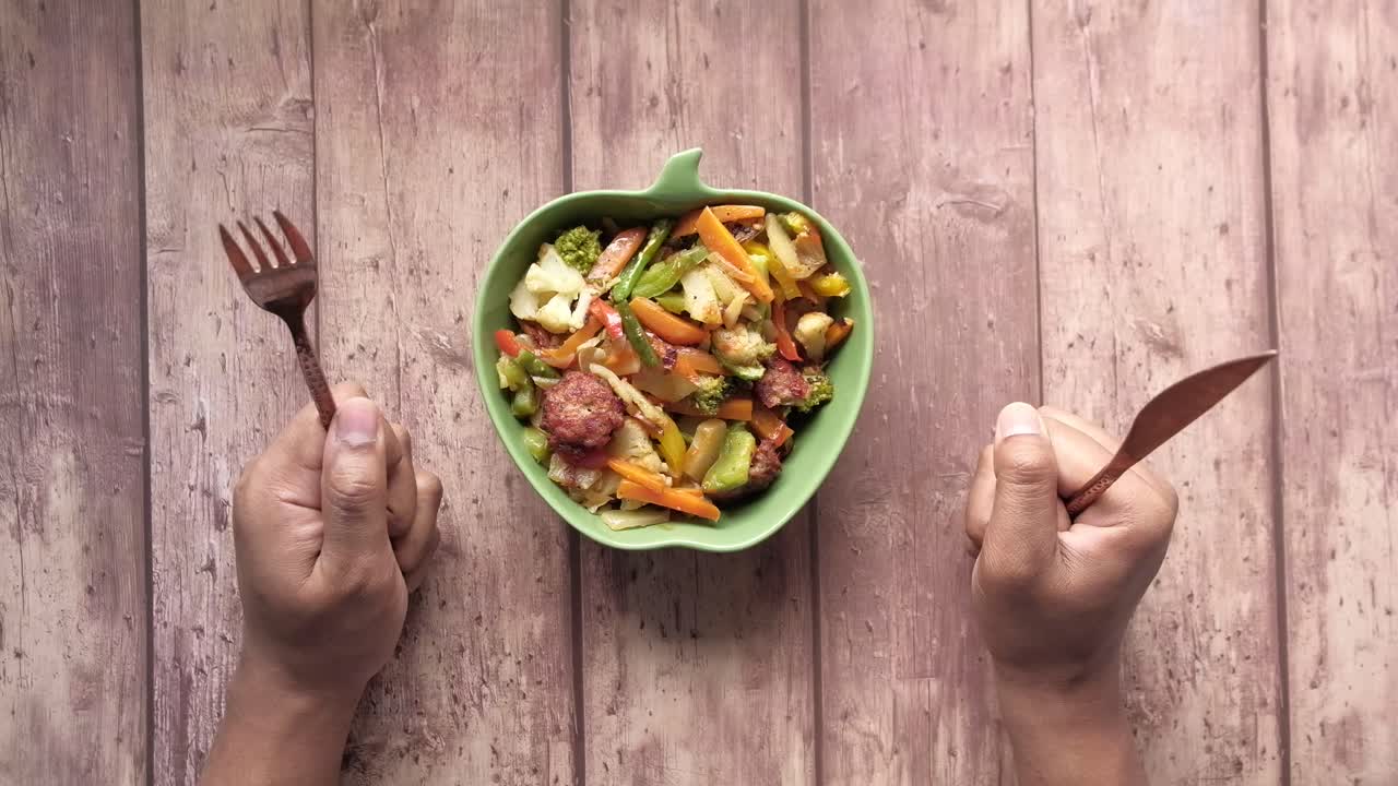 frito de verduras mezcladas con tenedor y cuchillo