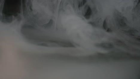 close-up of smoke pouring onto the surface and spreading across the table