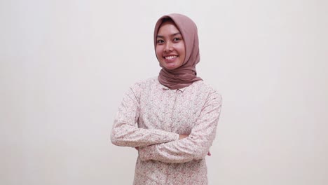 beautiful young asian muslim woman standing with folded hands while smiling