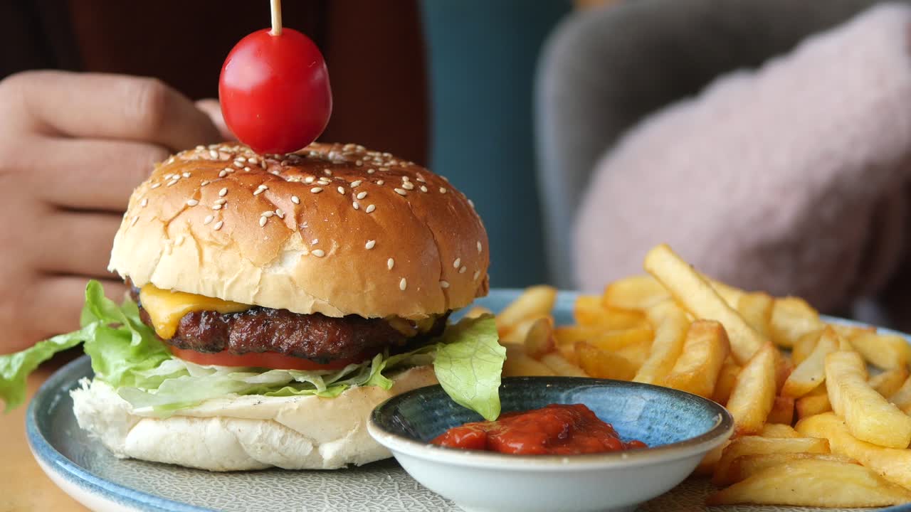 una jugosa hamburguesa con papas fritas y ketchup.