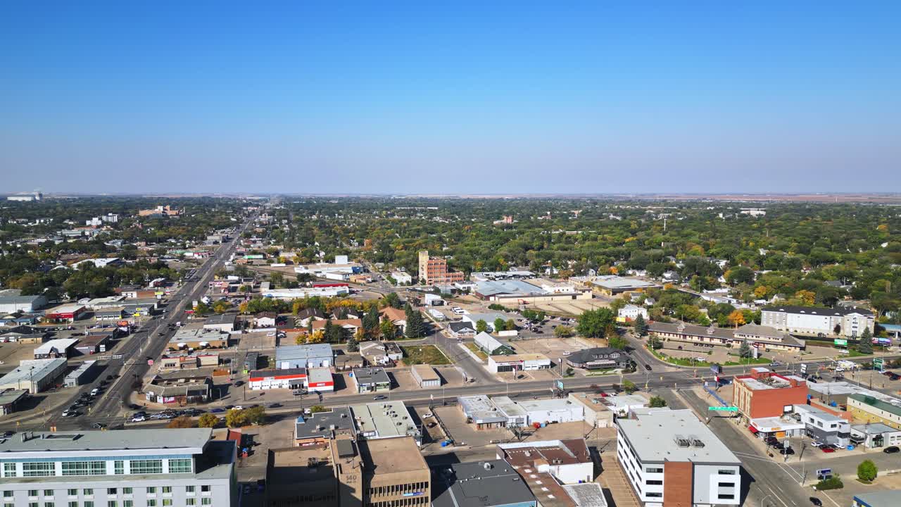 Aerial pan across old Saskatoon district with main road, homes, small shops