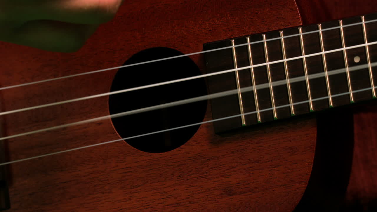 Hand strumming guitar strings close up