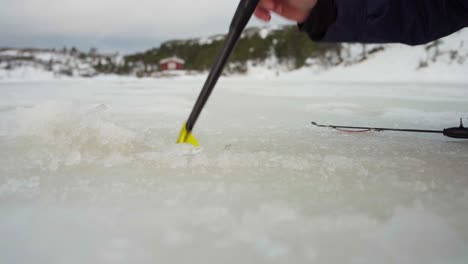 The-Man-is-Utilizing-an-Ice-Skimmer-During-His-Ice-Fishing-Expedition-in-Bessaker,-Trondelag-County,-Norway---Close-Up