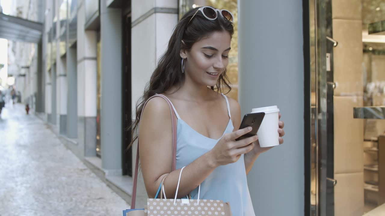 mujer sonriente usando teléfono inteligente, leyendo chat y tomando café