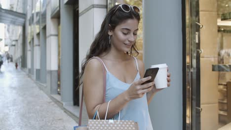 Lächelnde-Frau,-Die-Smartphone-Benutzt,-Chat-Liest-Und-Kaffee-Trinkt