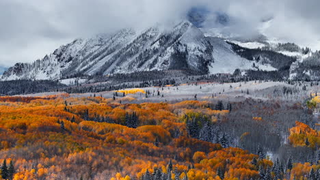 impresionante paso kebler crested butte colorado impresionante otoño invierno primeras estaciones de nieve chocan aéreo cinematográfico dron árbol de abeto amarillo bosque montañas rocosas nubes de niebla levantando hacia abajo movimiento jib