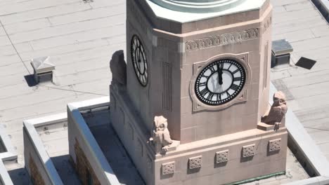 An-aerial-view-of-an-old-clock-tower-on-a-school-building,-with-the-track-and-field-in-the-background-on-a-sunny-day-on-Long-Island,-NY