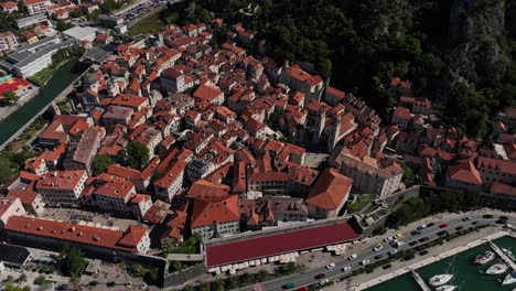 Wide aerial of old town and street traffic by marina in Kotor, Montenegro