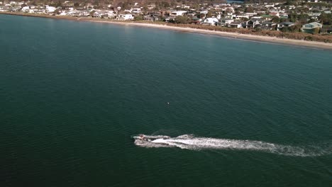 Cinematic-drone-video-of-Jet-Ski-skimming-across-the-water-at-sunset