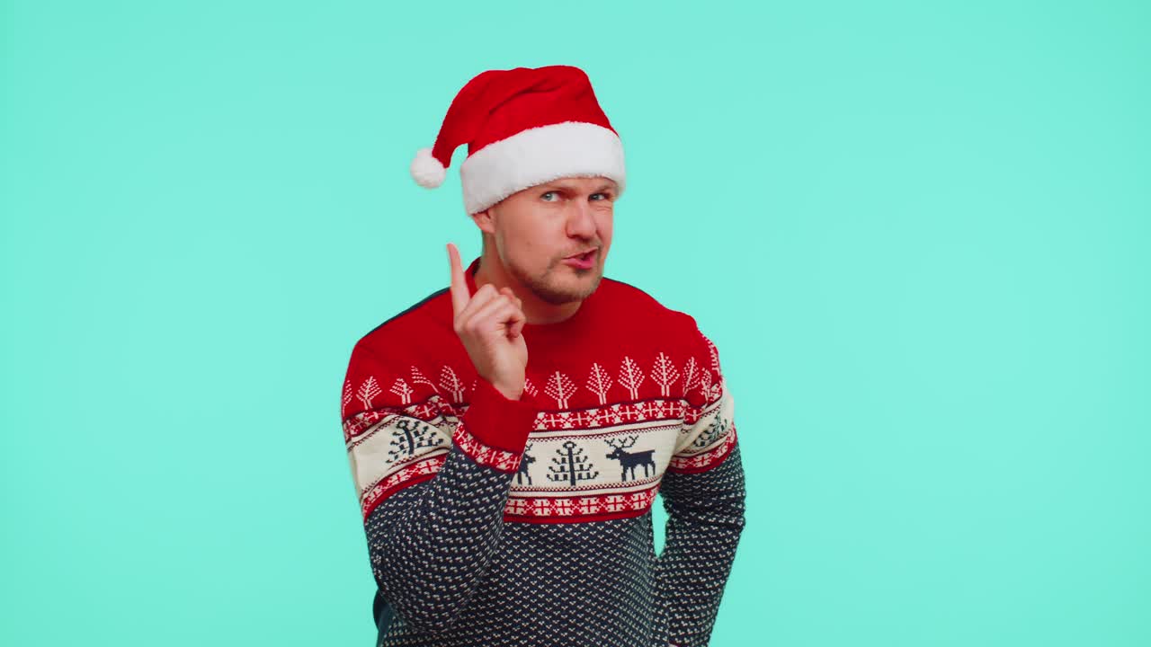 Displeased man in christmas sweater gesturing hands with displeasure blaming scolding for failure