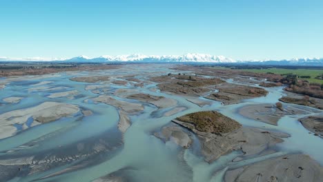 Aerial-view-of-beautiful-Rakaia-River-colors-on-a-clear,-calm-mid-winter's-day---channels,-vast-landscape-and-mountains