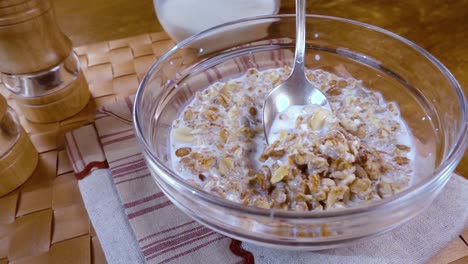 whole grain cereal muesli in a bowl for a morning delicious breakfast with milk. slow motion with rotation tracking shot.