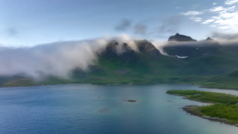 nubes rodando sobre las cimas de las montañas durante el amanecer en noruega