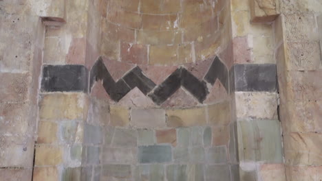 the camera scans the hewn stone mihrab of zinciriye madrasa from bottom to top, and finally we see the stone inscriptions on the mihrab