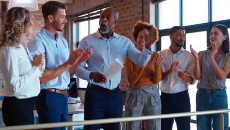 Colegas-Aplaudiendo-Y-Estrechando-La-Mano-Del-Empresario-Que-Lidera-La-Reunión-Del-Equipo-En-Una-Oficina-Multicultural