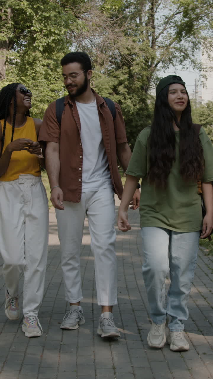 Young adults walking and talking in a park