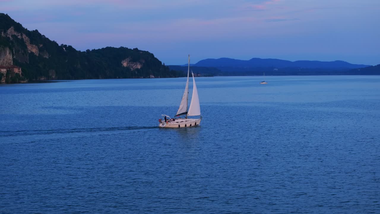 un velero navegando al atardecer a través del increíble lago maggiore en italia