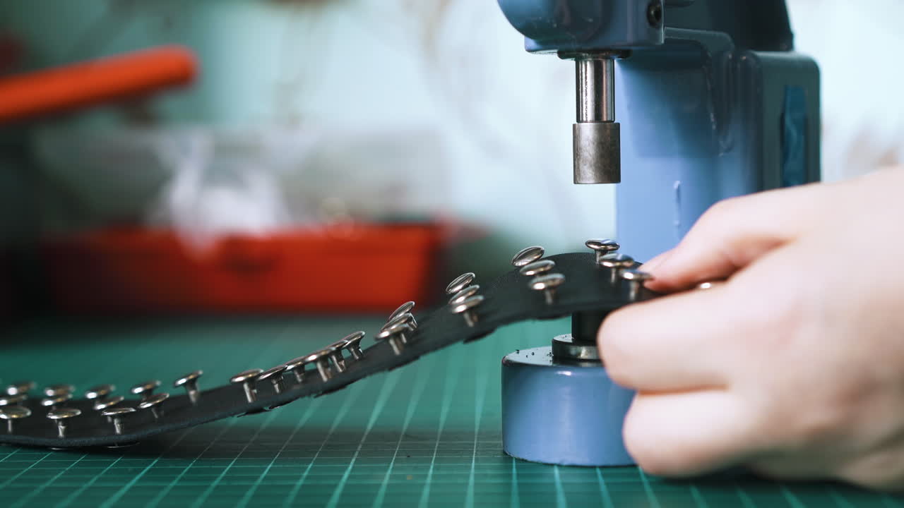 Skilled designer sets silver holnitens into leather choker