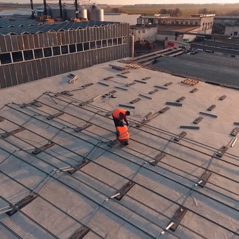 installation solar panels on a roof. workers put metal constructions before installing solar panels on a roof of a big building. top view.