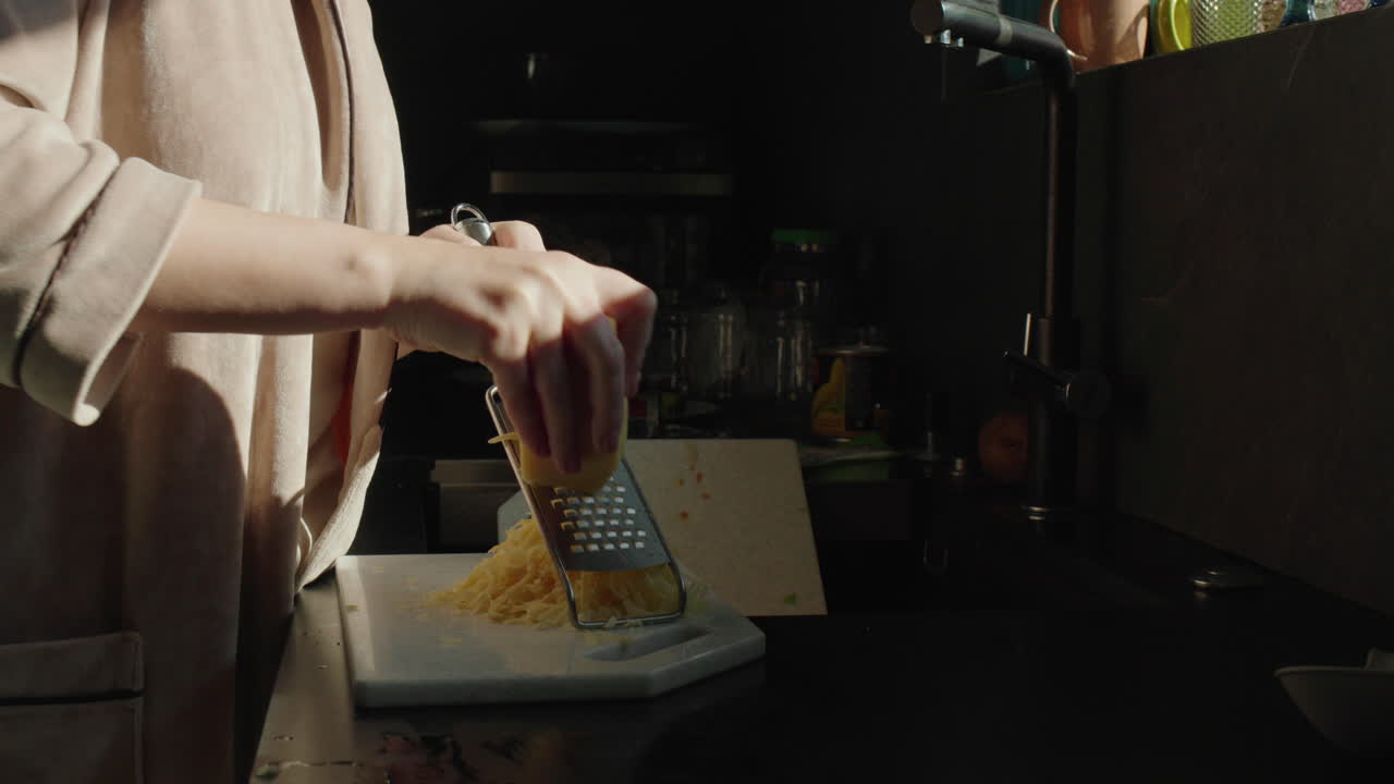 mujer rastrillando queso o manzana en una cocina