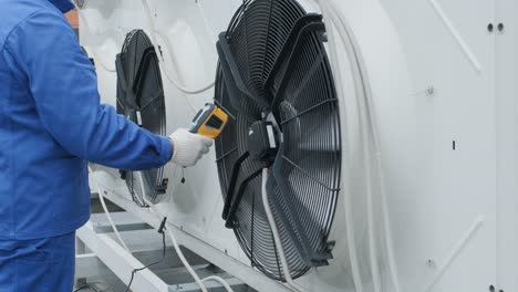 technician uses a thermal imaging infrared thermometer to check the condensing unit heat exchanger
