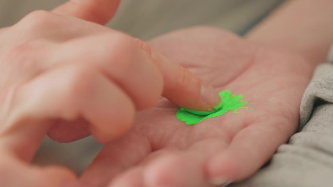 Close-up of a Child's Hand Playing with Bright Green Paint
