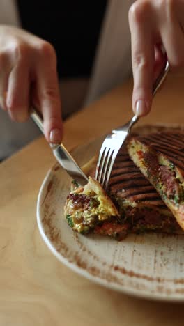 woman eating a grilled panini sandwich