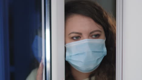 woman wearing mask looking through window