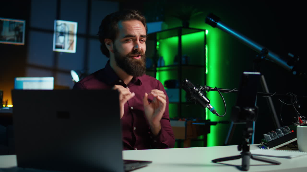 estrella de los medios feliz usando un teléfono inteligente en un trípode para filmar la introducción del canal de vlog