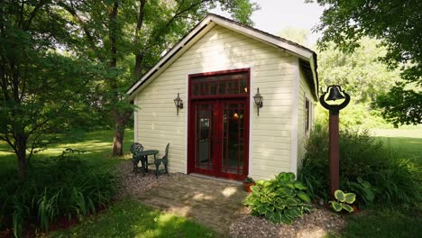 push-in-shot-of-the-exterior-of-a-white-school-house-with-red-doors-on-a-sunny-day