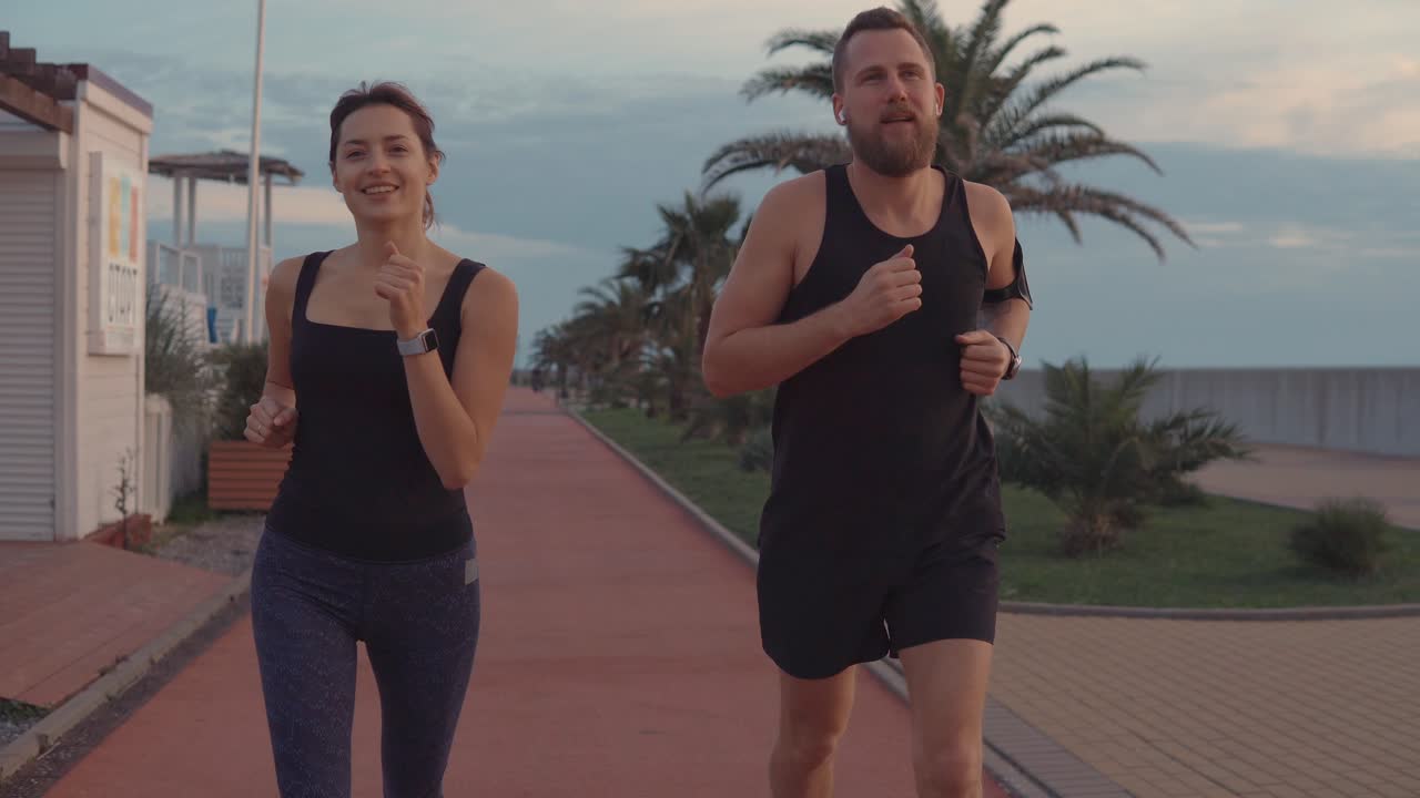 pareja corriendo por un camino frente a la playa