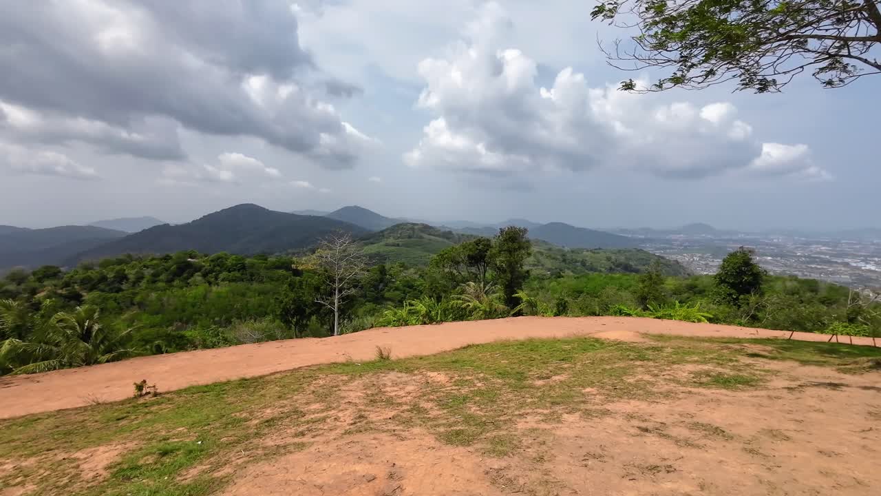 Promthep Cape viewpoint in Phuket, Thailand, showing panoramic ocean horizon, lush tropical coastline, offshore islands, palm trees, and vibrant atmosphere