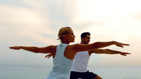 Hombre-Y-Mujer-Haciendo-Yoga-En-La-Playa