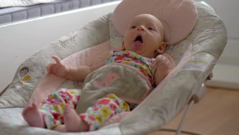 baby of two months in rocking chair at home
