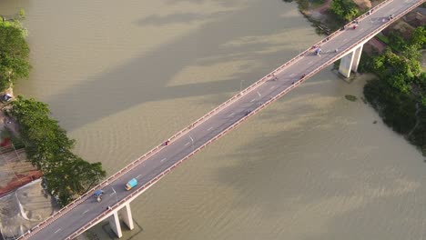 Vehículos-Con-Vista-De-Arriba-Hacia-Abajo-Que-Cruzan-El-Puente-Gabkhan-Sobre-El-Río-De-Agua-Turbia,-Bangladesh