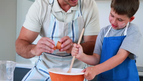 padre y hijo sonrientes haciendo un pastel juntos