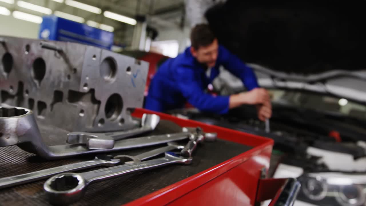piezas de automóviles con herramientas y mecánico trabajando en el fondo