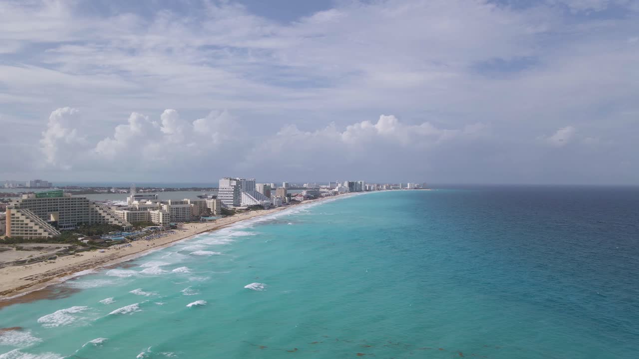 Vista aerea di un bellissimo oceano a Cancún, Messico, con resort lungo la spiaggia, ripresa orbitale.