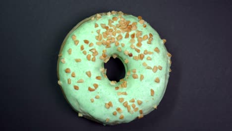 tasty and fresh sprinkled donut close-up macro shot spinning on a black background.