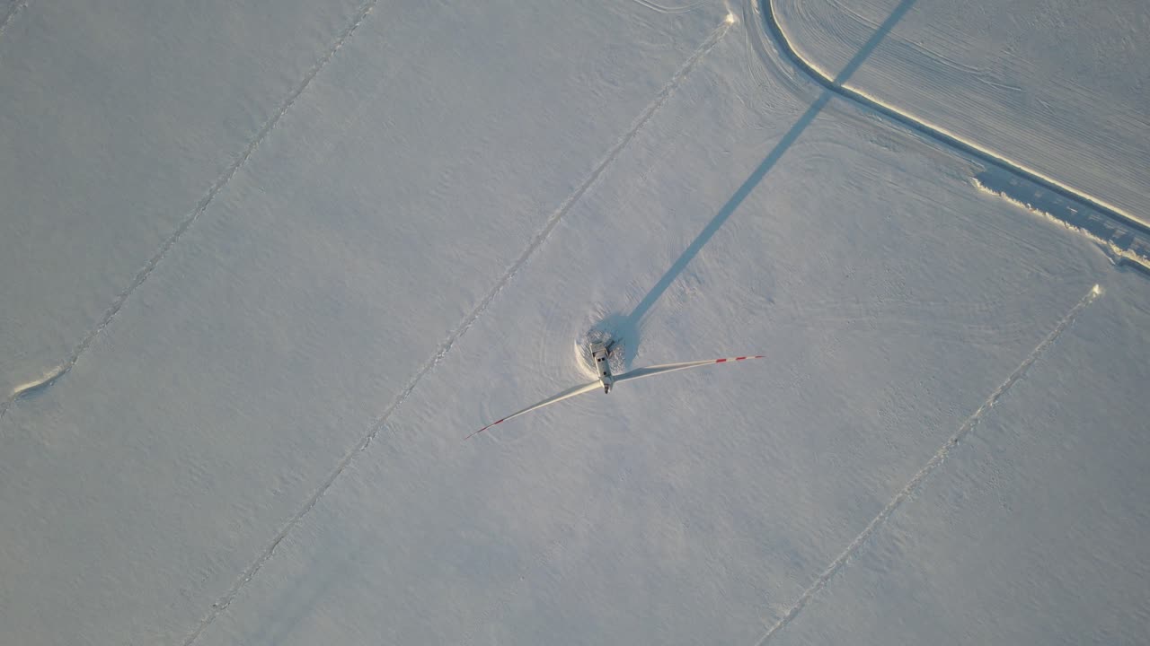 폴란드의 눈 덮인 농장에서 풍력 터빈의 상위 뷰