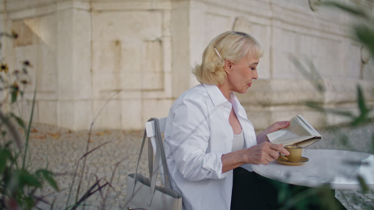 커피하우스에서 신문을 읽는 성숙한 여인. 커피를 마시는 은퇴자