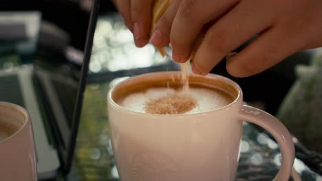 close-up with selective focus pouring sugar to a latte