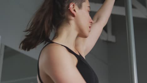 mujer caucásica haciendo pole dance