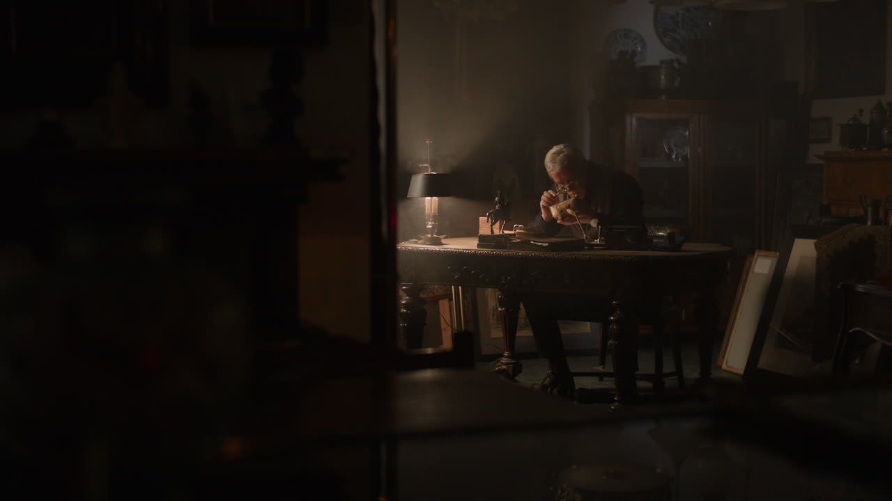 Older passionate man evaluates an old porcelain box