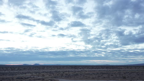 the mojave desert landscape at dawn on an overcast day - sliding aerial view