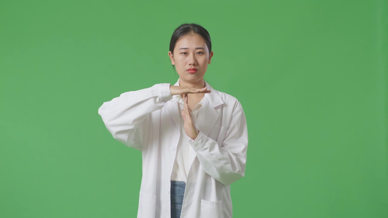 실험실 코트를 입은 여성이 타임아웃을 제스처하고 있습니다.