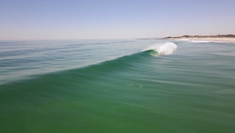 Drohnenschuss,-Der-An-Einem-Schönen,-Klaren,-Sonnigen-Tag-über-Eine-Welle-Fliegt,-Die-An-Einem-Leeren-Strand-Bricht